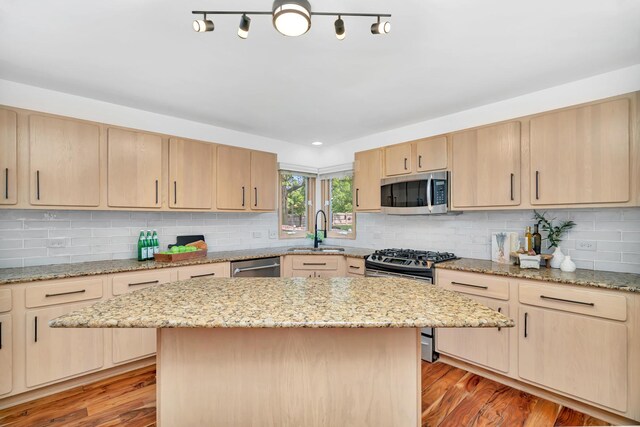 5024 Switch Grass Ln, Naperville, IL 60564 - kitchen featuring stainless steel appliances, light brown cabinetry, light wood finished floors, light stone countertops, and tasteful backsplash