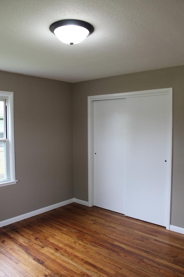 207 Cedar Dr, Clinton, IL 61727 - unfurnished bedroom featuring wood finished floors and a closet