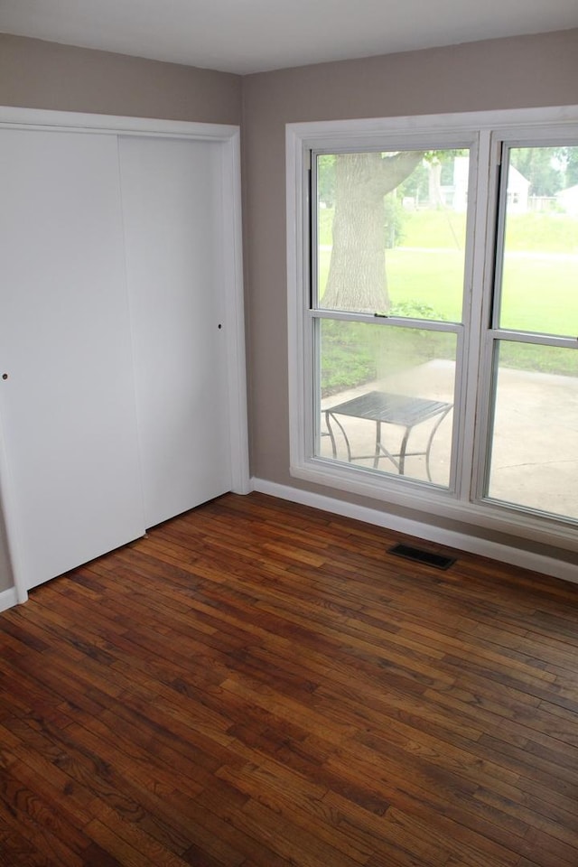 207 Cedar Dr, Clinton, IL 61727 - unfurnished bedroom with dark wood-style flooring and a closet
