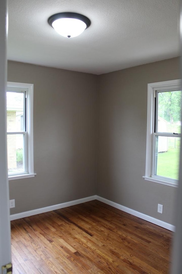 207 Cedar Dr, Clinton, IL 61727 - spare room with wood finished floors, plenty of natural light, and a textured ceiling