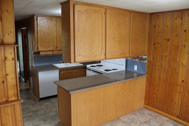 207 Cedar Dr, Clinton, IL 61727 - kitchen with white appliances, a peninsula, light flooring, brown cabinets, and dark countertops