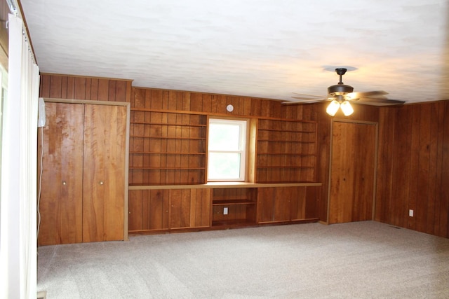 207 Cedar Dr, Clinton, IL 61727 - unfurnished living room featuring wooden walls, carpet, and a ceiling fan