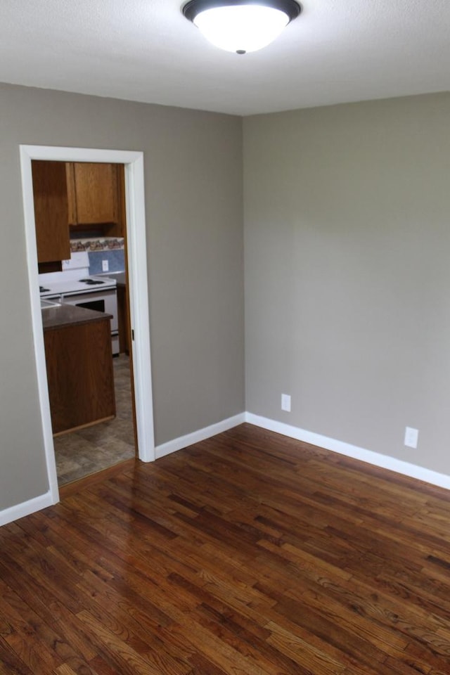 207 Cedar Dr, Clinton, IL 61727 - spare room featuring dark wood-style floors and baseboards
