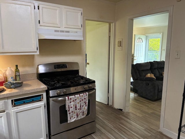 314 Meota St, Park Forest, IL 60466 - kitchen with gas stove, under cabinet range hood, white cabinetry, wood finished floors, and light countertops