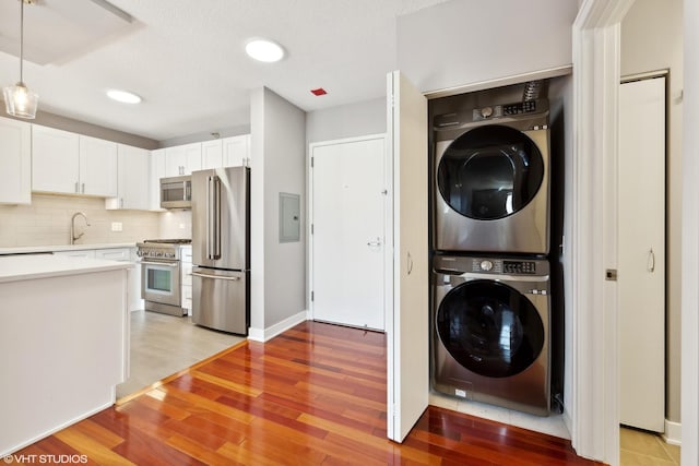 545 N Dearborn St Unit 3207, Chicago, IL 60654 - laundry area featuring stacked washer and clothes dryer, light wood-style flooring, and electric panel