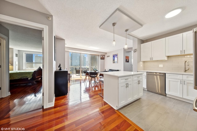 545 N Dearborn St Unit 3207, Chicago, IL 60654 - kitchen with dishwasher, light countertops, white cabinets, a textured ceiling, and tasteful backsplash