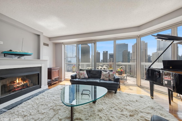 545 N Dearborn St Unit 3207, Chicago, IL 60654 - living area featuring a view of skyline, a textured ceiling, wood finished floors, and a warm lit fireplace