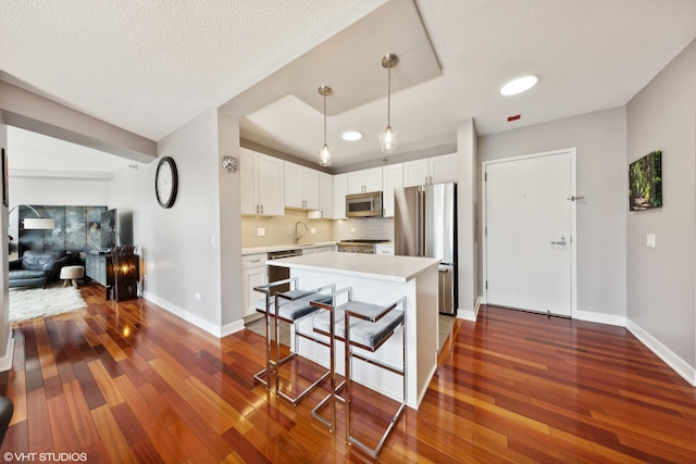 545 N Dearborn St Unit 3207, Chicago, IL 60654 - kitchen featuring stainless steel appliances, dark wood-style flooring, light countertops, backsplash, and white cabinets