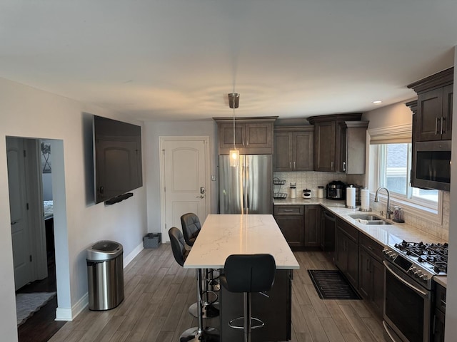 7743 Cronin Ave, Justice, IL 60458 - kitchen featuring appliances with stainless steel finishes, dark wood finished floors, a kitchen island, tasteful backsplash, and dark brown cabinets