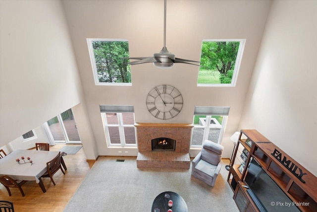 1103 Paul Ct, Fox River Grove, IL 60021 - living area featuring a high ceiling, a fireplace, ceiling fan, and wood finished floors