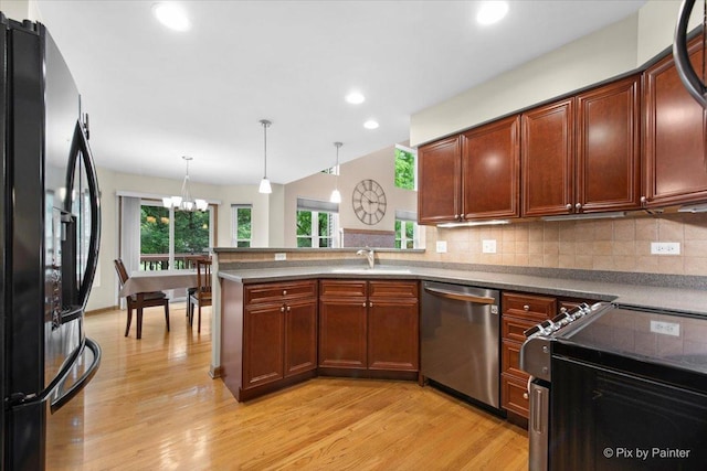 1103 Paul Ct, Fox River Grove, IL 60021 - kitchen featuring appliances with stainless steel finishes, light wood-style flooring, a chandelier, tasteful backsplash, and a peninsula