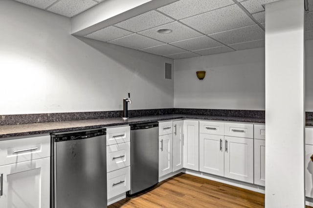 184 Primrose Ln, Bartlett, IL 60103 - kitchen featuring a paneled ceiling, stainless steel dishwasher, white cabinets, dark countertops, and light wood-type flooring