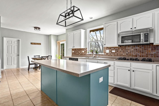 184 Primrose Ln, Bartlett, IL 60103 - kitchen featuring black appliances, light tile patterned floors, a center island, tasteful backsplash, and white cabinetry