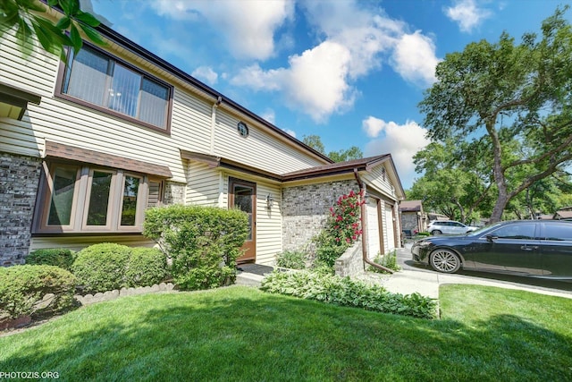 1330 S Mallard Ln, Mount Prospect, IL 60056 - view of front of property with a front yard, a garage, stone siding, and concrete driveway