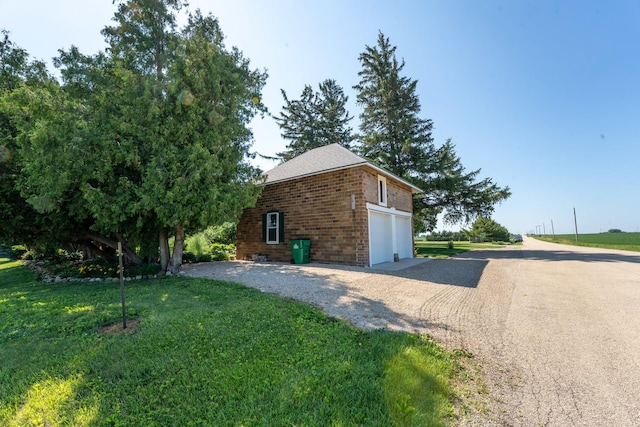 1392 Red Brick Rd, Dixon, IL 61021 - view of side of property featuring gravel driveway, brick siding, a garage, and a yard