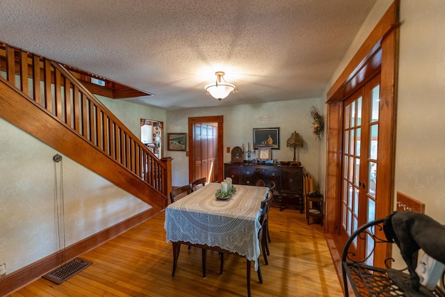 1392 Red Brick Rd, Dixon, IL 61021 - dining space with french doors, wood-type flooring, a textured ceiling, and stairway