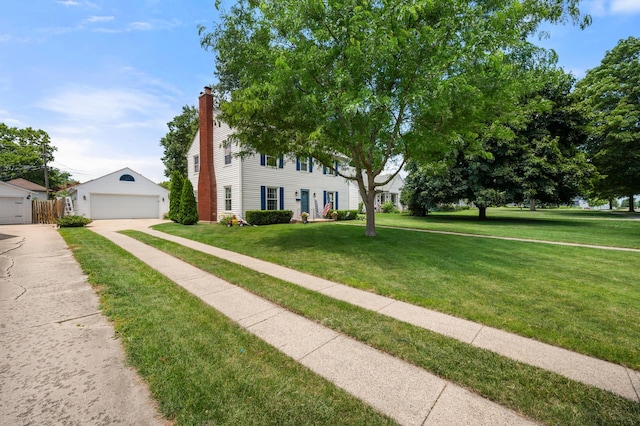 1050 N 8th St, Rochelle, IL 61068 - colonial-style house featuring a front yard, a garage, an outbuilding, and a chimney