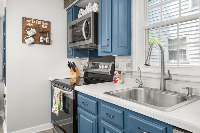1050 N 8th St, Rochelle, IL 61068 - kitchen featuring stainless steel appliances, blue cabinets, and light countertops