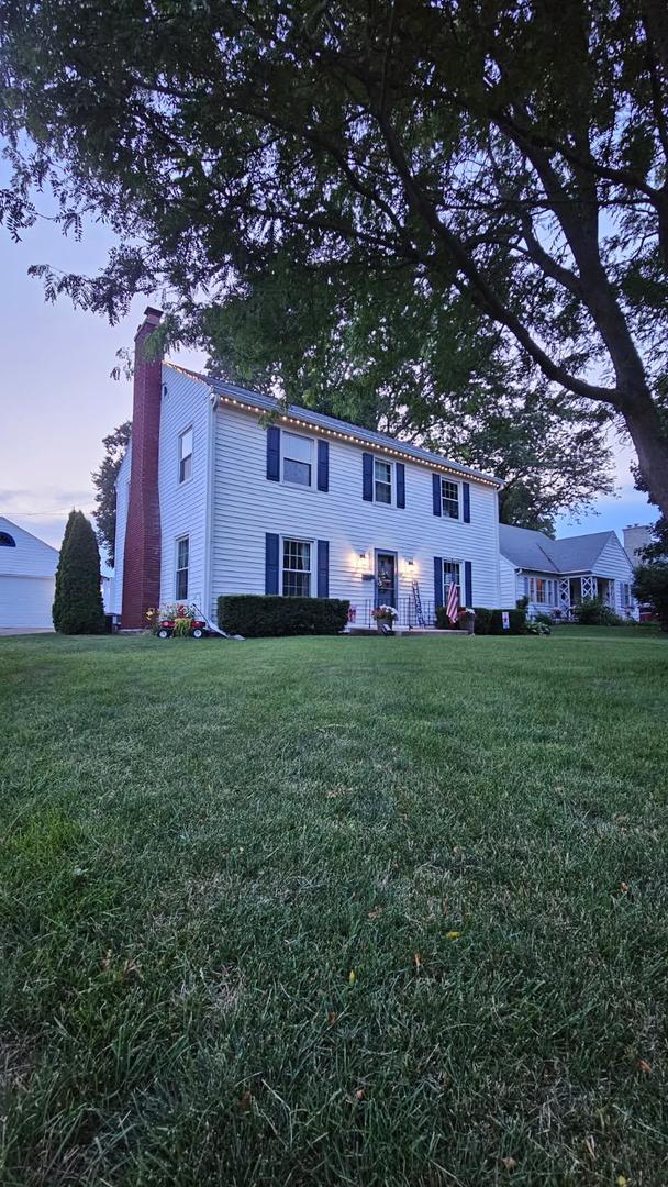 1050 N 8th St, Rochelle, IL 61068 - view of front of property with a chimney and a lawn