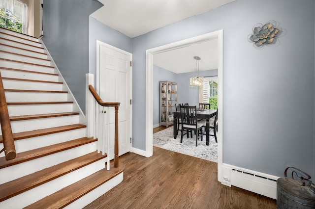 1050 N 8th St, Rochelle, IL 61068 - entrance foyer with a baseboard radiator, a chandelier, stairs, and dark wood-style floors