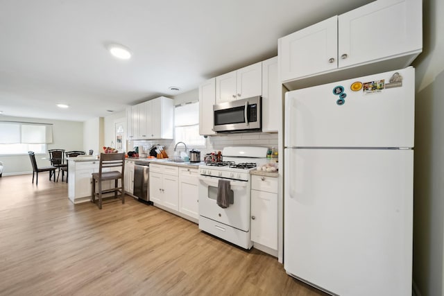 3348 N Narragansett Ave, Chicago, IL 60634 - kitchen with stainless steel appliances, light countertops, white cabinets, light wood-type flooring, and backsplash