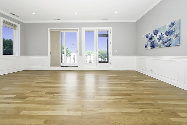 5010 W Lawrence Ave Unit 3B, Chicago, IL 60630 - empty room featuring plenty of natural light, light wood-type flooring, ornamental molding, wainscoting, and a decorative wall