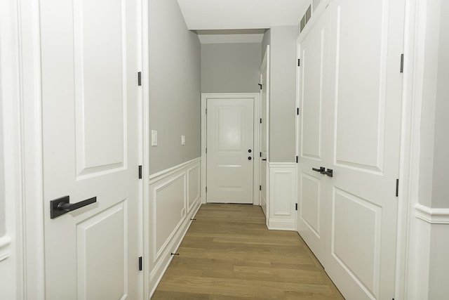 5010 W Lawrence Ave Unit 3B, Chicago, IL 60630 - hall with light wood-style flooring, a decorative wall, and wainscoting