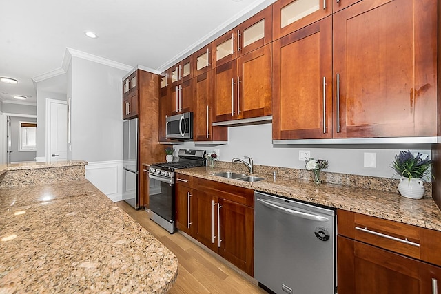 5010 W Lawrence Ave Unit 3B, Chicago, IL 60630 - kitchen featuring appliances with stainless steel finishes, ornamental molding, light stone countertops, light wood-type flooring, and wainscoting