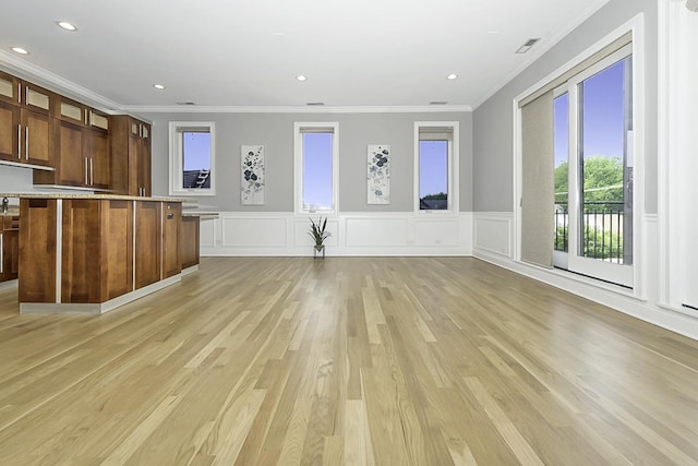 5010 W Lawrence Ave Unit 3B, Chicago, IL 60630 - unfurnished living room featuring plenty of natural light, ornamental molding, light wood-style flooring, a decorative wall, and a wainscoted wall