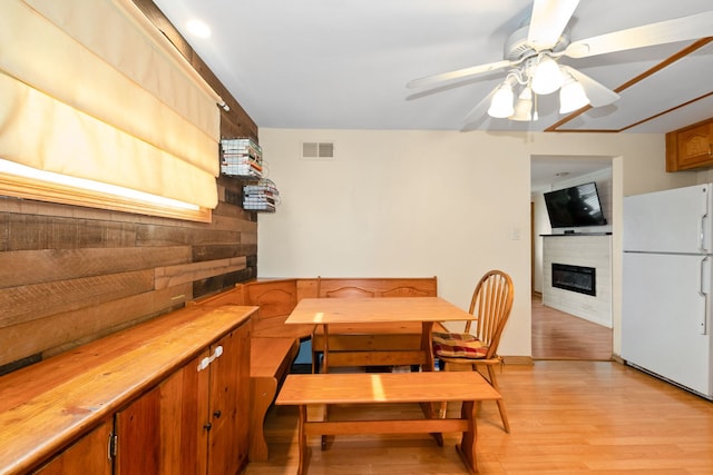 4631W W 88th St, Hometown, IL 60456 - dining room featuring light wood-type flooring, a large fireplace, a ceiling fan, and wood walls