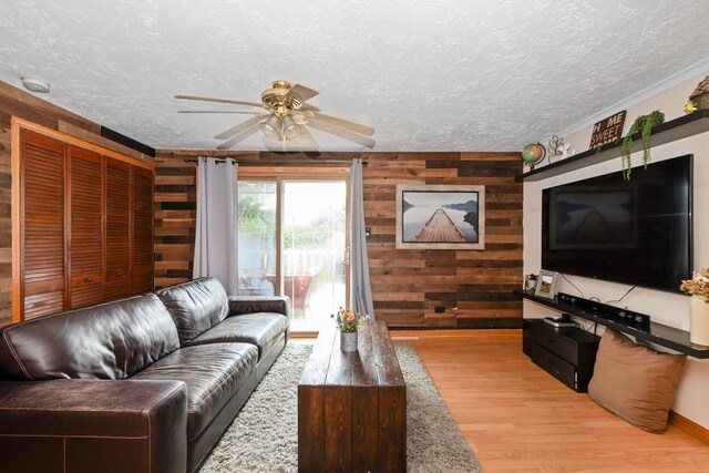 4631W W 88th St, Hometown, IL 60456 - living room featuring wood walls, light wood-type flooring, a ceiling fan, and a textured ceiling