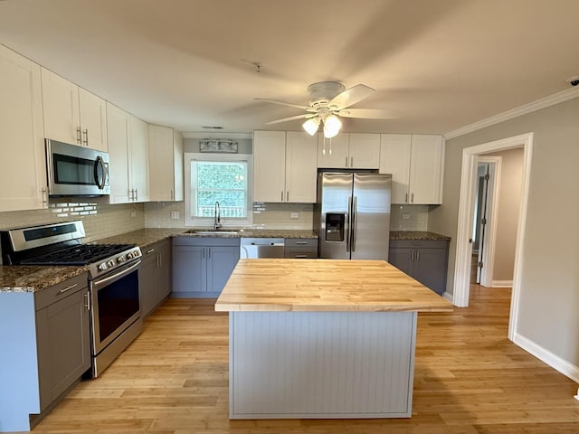 408 Sauk Trl, Park Forest, IL 60466 - kitchen with stainless steel appliances, butcher block counters, a ceiling fan, a kitchen island, and tasteful backsplash