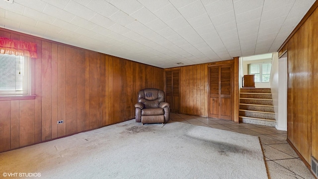80 E Fremont Ave, Des Plaines, IL 60016 - unfurnished room featuring plenty of natural light, wooden walls, stairway, carpet, and tile patterned flooring
