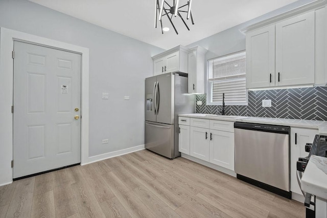 6721 S Ada St, Chicago, IL 60636 - kitchen featuring appliances with stainless steel finishes, light countertops, decorative backsplash, light wood-type flooring, and white cabinets