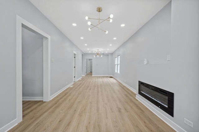 6721 S Ada St, Chicago, IL 60636 - unfurnished living room featuring a chandelier, light wood-style floors, a glass covered fireplace, and recessed lighting