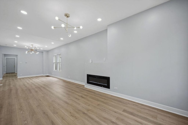 6721 S Ada St, Chicago, IL 60636 - unfurnished living room featuring a chandelier, light wood-type flooring, recessed lighting, and a glass covered fireplace