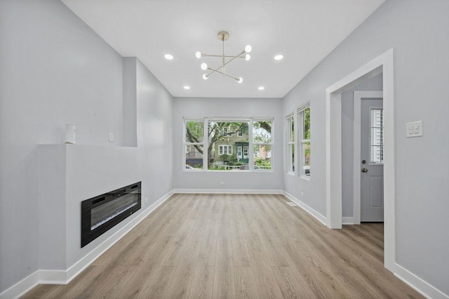 6721 S Ada St, Chicago, IL 60636 - unfurnished living room featuring wood finished floors, a chandelier, a glass covered fireplace, and recessed lighting
