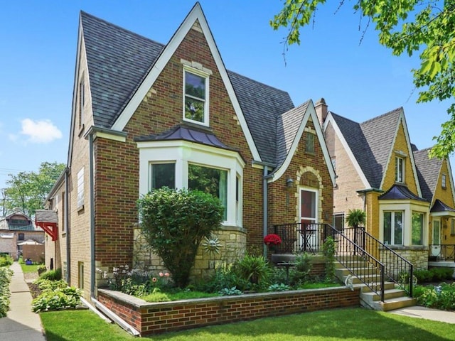 3010 Wisconsin Ave, Berwyn, IL 60402 - tudor-style house featuring brick siding, a chimney, a front lawn, and a shingled roof