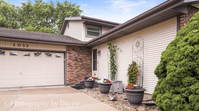 1033 Pheasant Dr, Bradley, IL 60915 - doorway to property featuring an attached garage, driveway, and brick siding