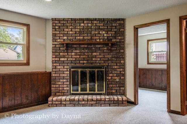 1033 Pheasant Dr, Bradley, IL 60915 - unfurnished living room featuring a brick fireplace, wood walls, a wainscoted wall, carpet flooring, and a textured ceiling