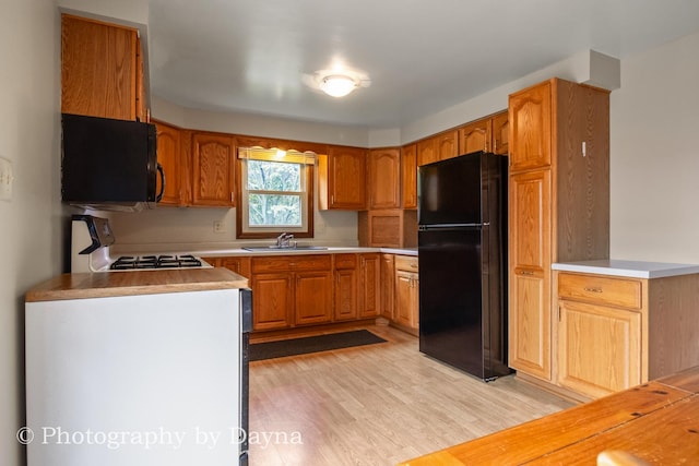 1033 Pheasant Dr, Bradley, IL 60915 - kitchen with black appliances, light wood-style flooring, light countertops, and brown cabinetry