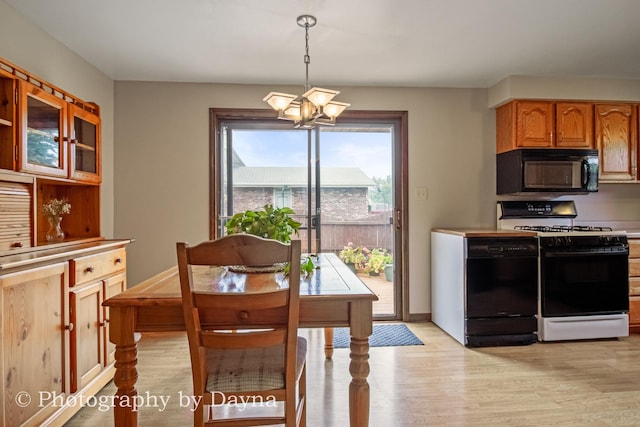 1033 Pheasant Dr, Bradley, IL 60915 - kitchen with black appliances, a chandelier, light wood-style floors, light countertops, and pendant lighting