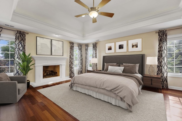 445 E Crescent Ave, Elmhurst, IL 60126 - bedroom featuring a tray ceiling, wood-type flooring, a fireplace with raised hearth, crown molding, and ceiling fan