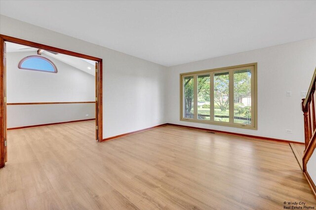 590 Woodcrest Ct, Carol Stream, IL 60188 - unfurnished room with plenty of natural light, light wood-style floors, and vaulted ceiling