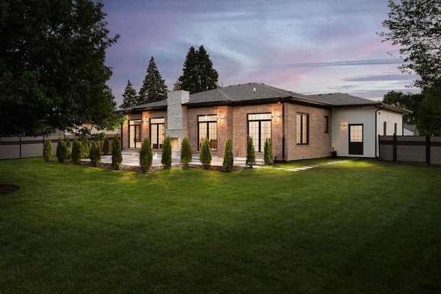 1847 Dexter Ln, Des Plaines, IL 60018 - back of house at dusk featuring a patio, brick siding, and roof with shingles