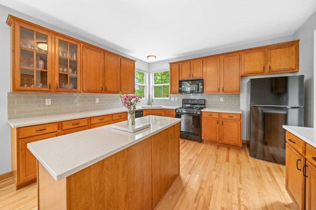4553 Gardiner Ave, Yorkville, IL 60560 - kitchen featuring black appliances, light wood-style flooring, brown cabinets, and backsplash