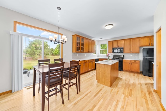 4553 Gardiner Ave, Yorkville, IL 60560 - kitchen with black appliances, brown cabinets, light wood finished floors, light countertops, and tasteful backsplash
