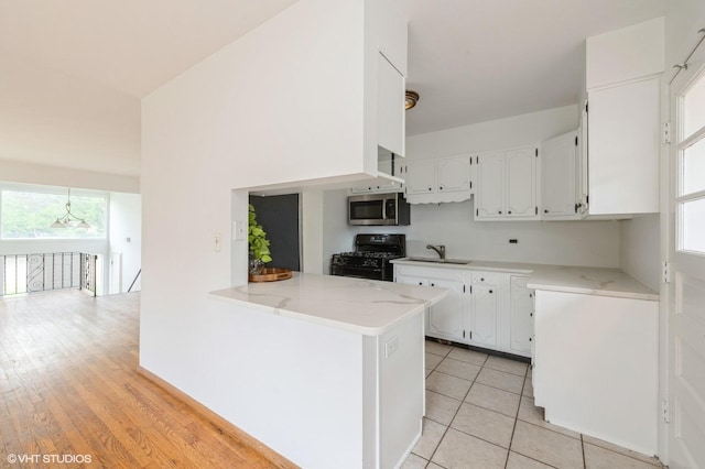 4321 Bay View Dr, Crystal Lake, IL 60014 - kitchen featuring stainless steel microwave, black range with gas stovetop, white cabinets, light stone countertops, and light tile patterned flooring