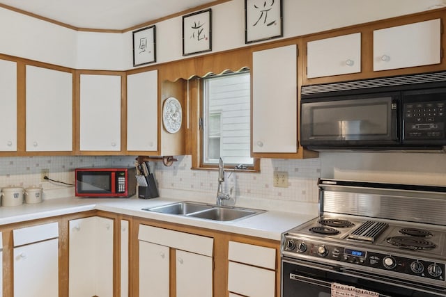 715 N 4th St, Dekalb, IL 60115 - kitchen featuring range with electric stovetop, black microwave, light countertops, backsplash, and white cabinetry