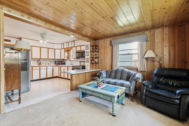715 N 4th St, Dekalb, IL 60115 - living room with light colored carpet, wood walls, wooden ceiling, and a ceiling fan